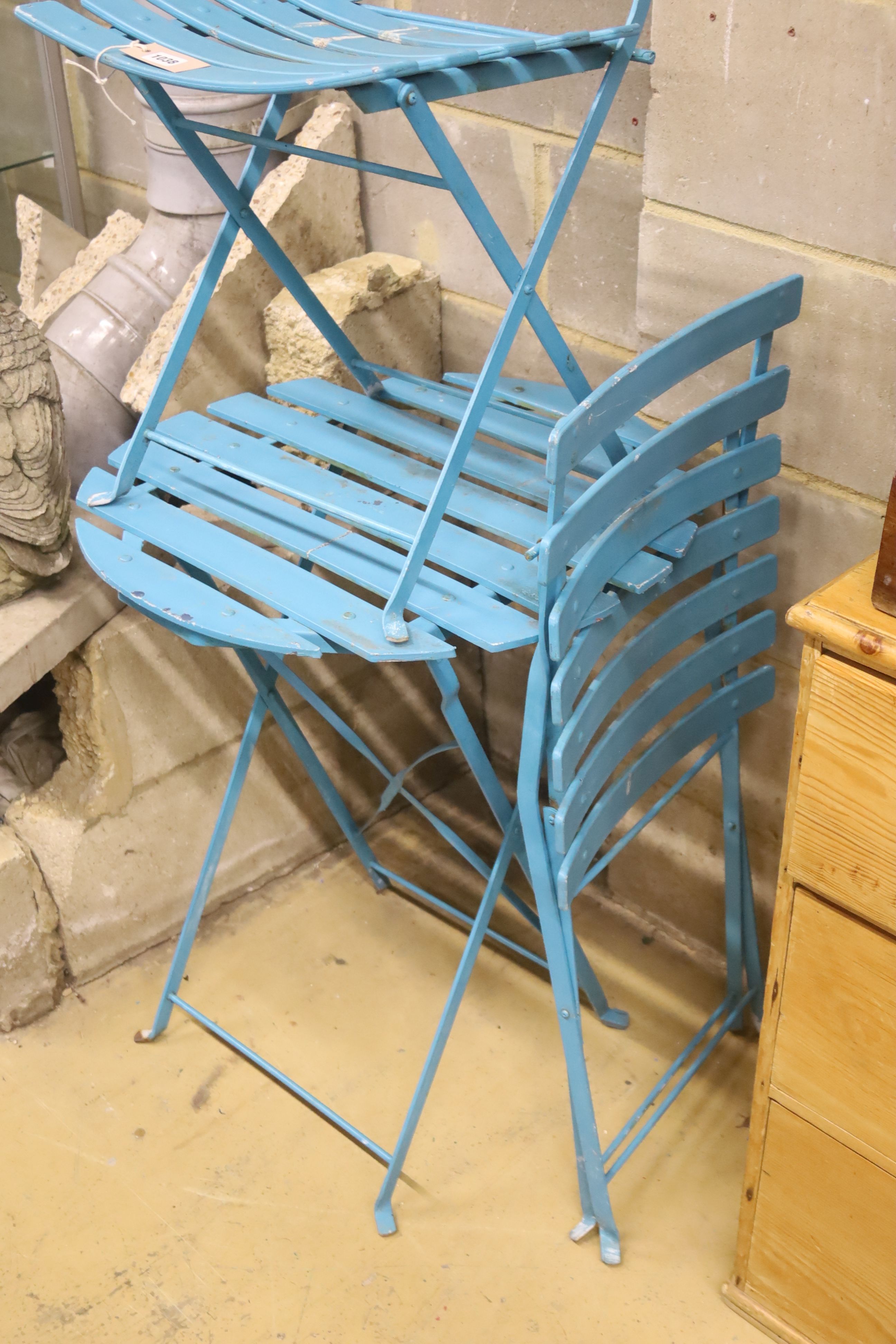 A slatted wrought iron folding garden table, 60cm diameter together with two matching chairs